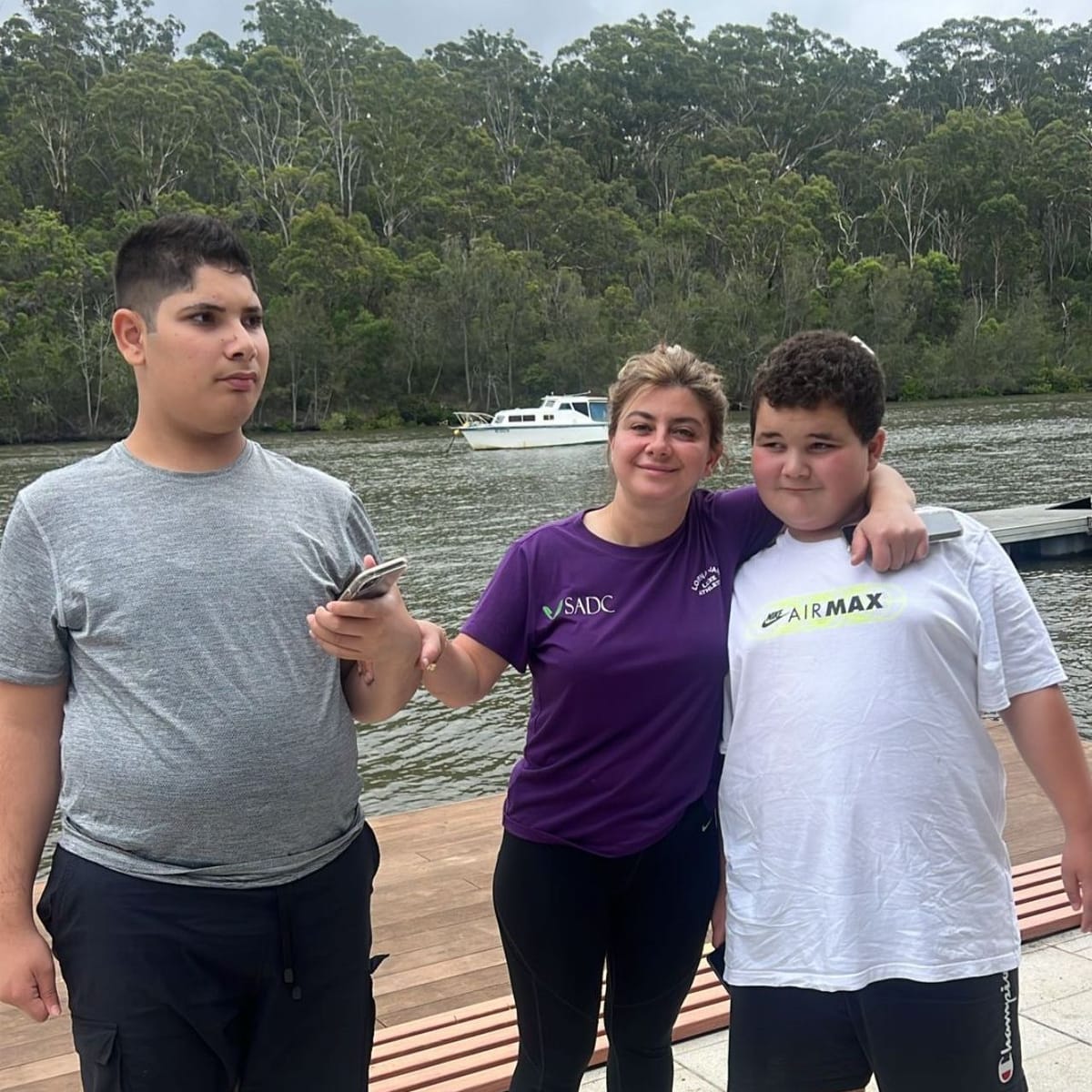 SADC support worker with two young participants on a riverside outing
