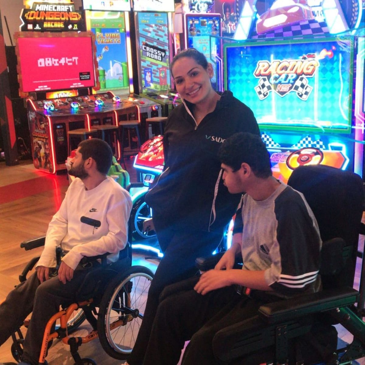 SADC support worker with two participants at an arcade