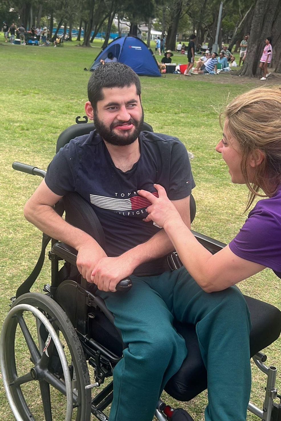 SADC support worker chatting with a participant during a day out in the park