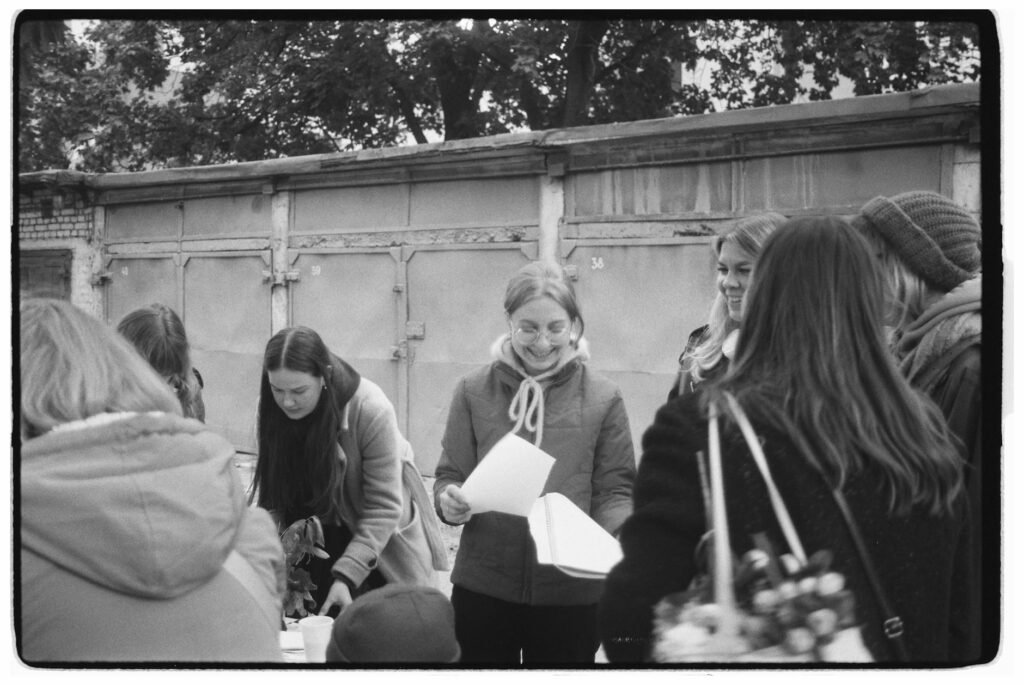 A group of women interacting at an outdoor gathering, smiling and engaged.